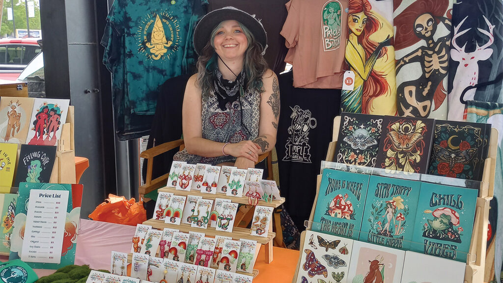 Artist Michelle Marcum At A Booth With Her Artwork