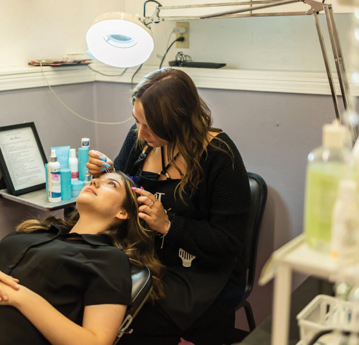 Cosmetology student works on esthetician skills by shaping eyebrows