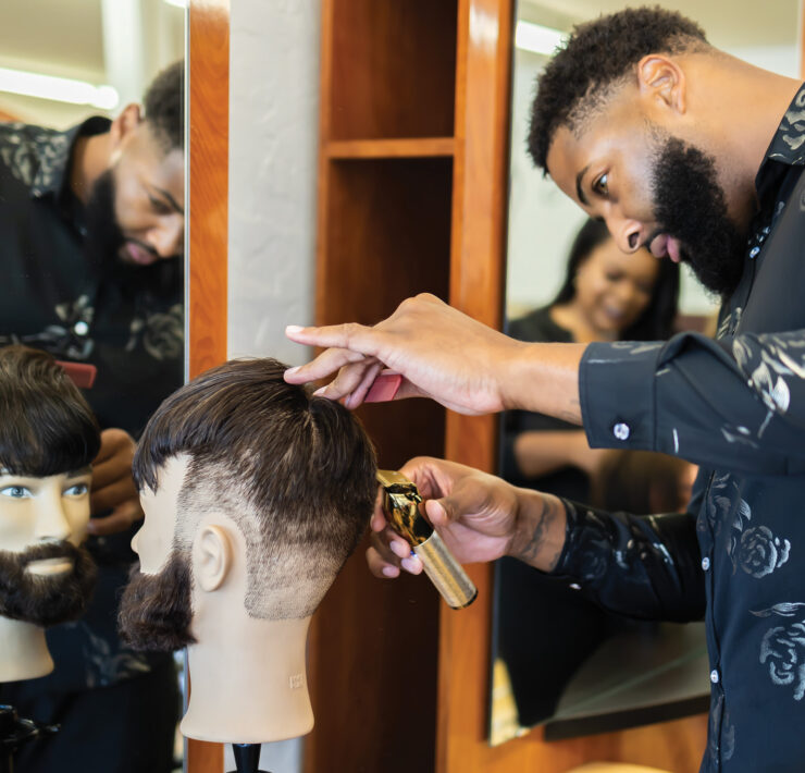 Student works on barber skills by working on mannequin