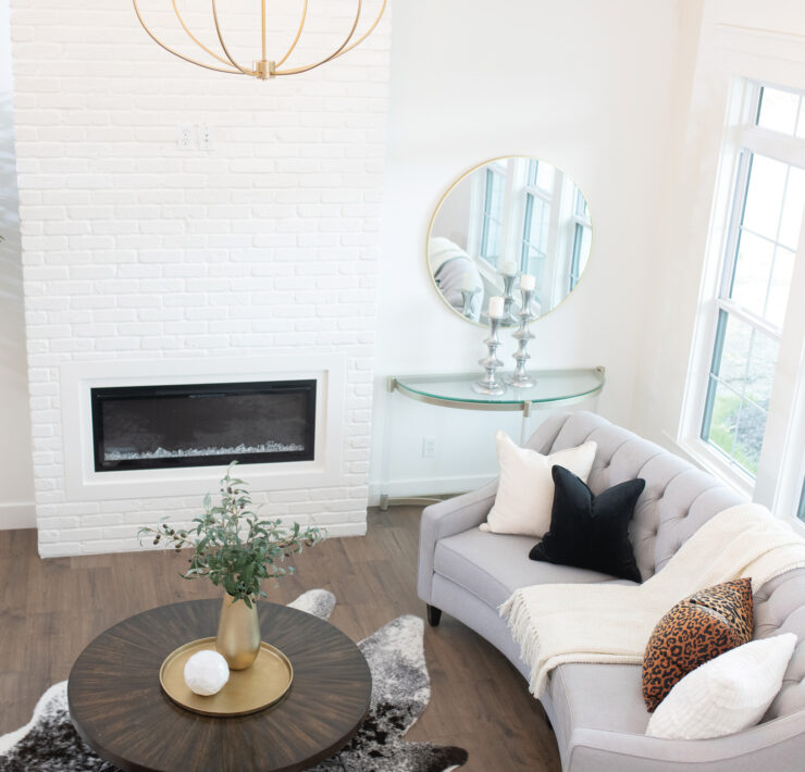 Wide shot of living room with tall white brick fireplace
