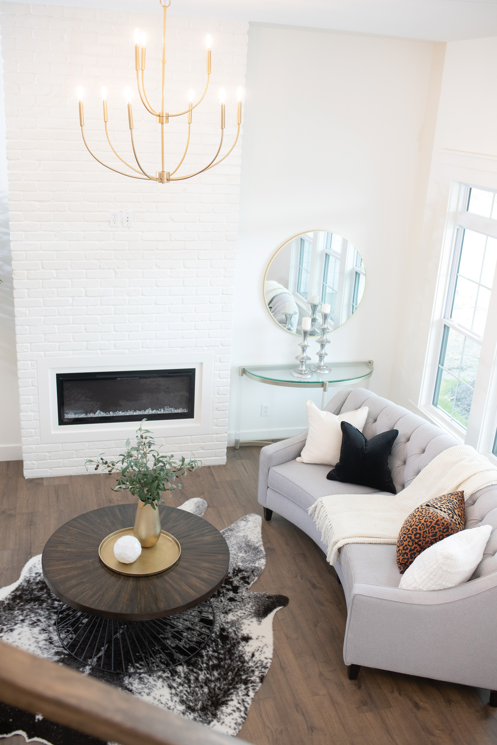 Wide shot of living room with tall white brick fireplace