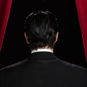 Business Man Standing Behind Curtains On Stage Featured