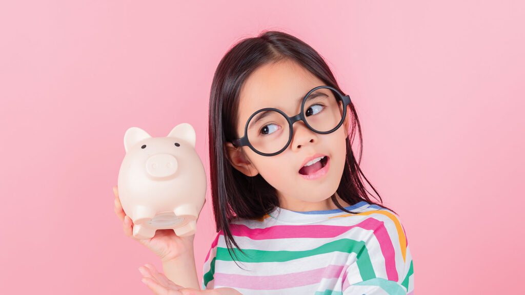 Young Girl Listening To Piggy Bank