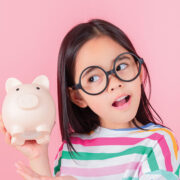 Young Girl Listening To Piggy Bank