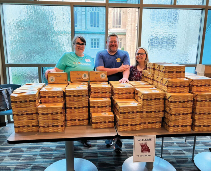 Table full of boxed lunches to give away at Project Homeless Connect