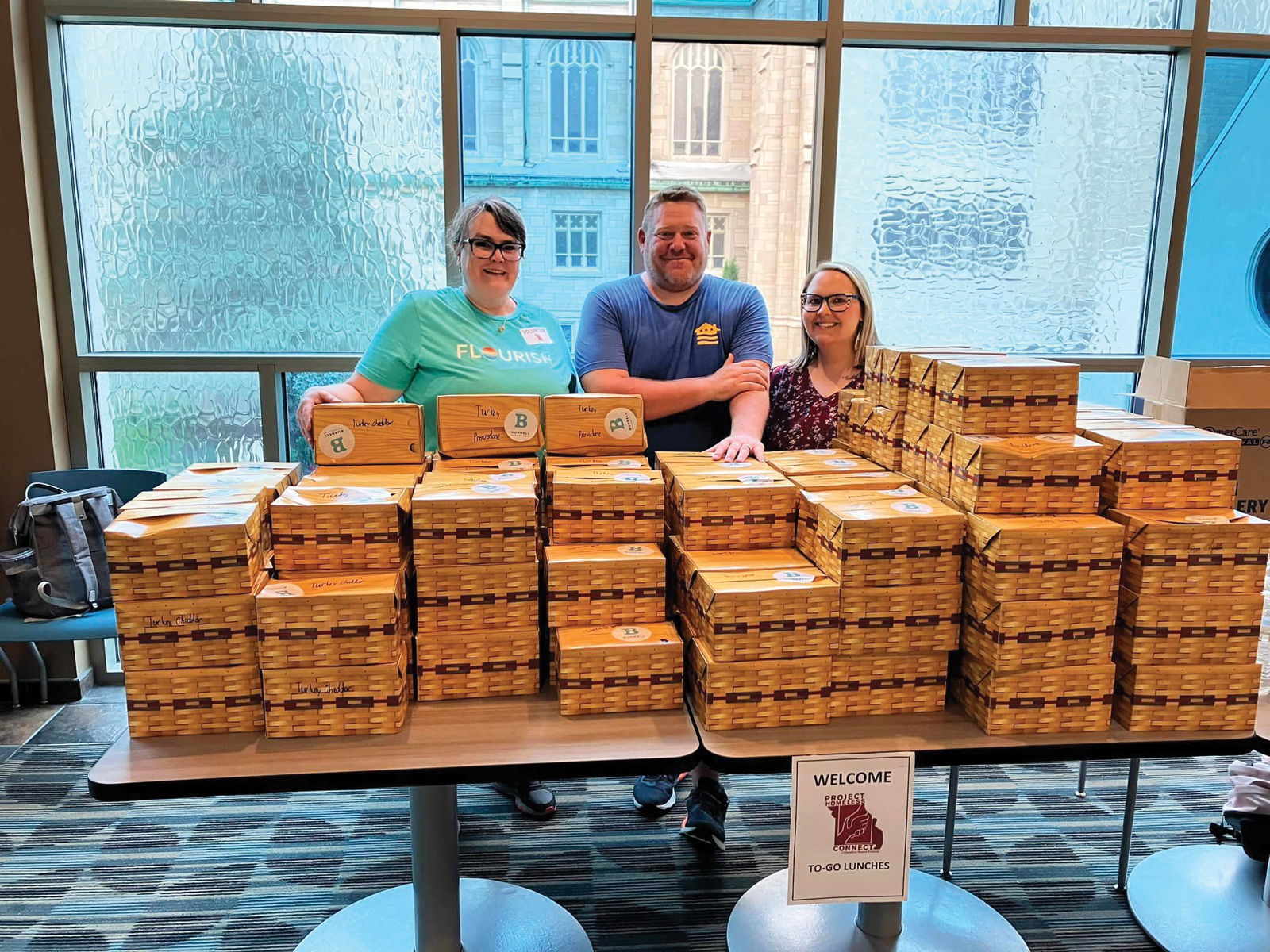 Table full of boxed lunches to give away at Project Homeless Connect