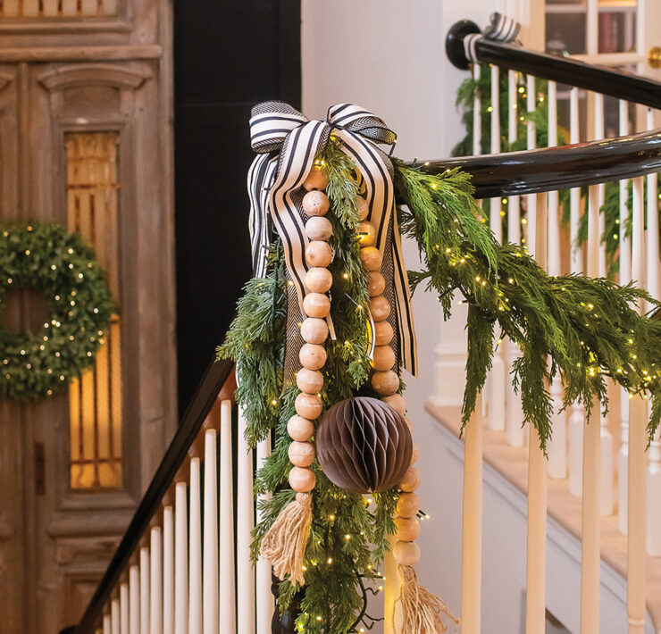 Banister decorated with holiday greenery and Christmas lights