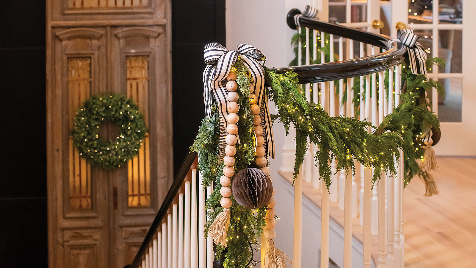 Banister decorated with holiday greenery and Christmas lights