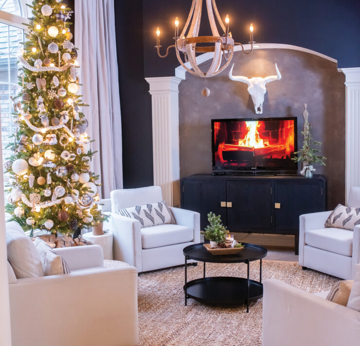 Bold and dramatic sitting room featuring a neutral Christmas tree wooden chandelier animal skull and yule log on TV