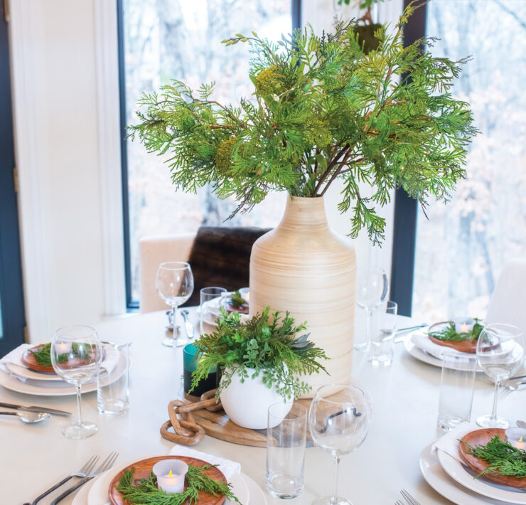 Holiday tablescape featuring natural greenery and wood textures