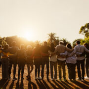 Back View Of Happy Multigenerational People Having Fun In A Public Park During Sunset Time Community And Support Concept