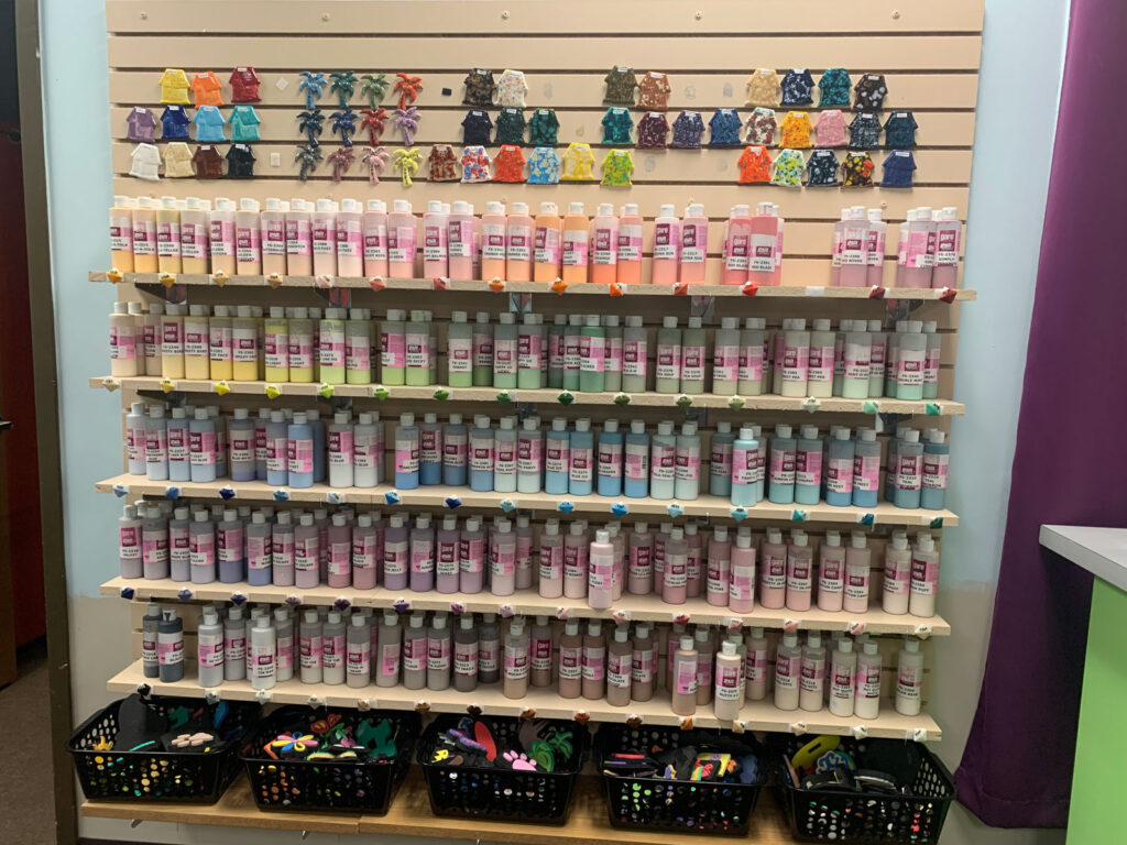 Large Wall of Shelves Filled with Bottles of Paint and Glaze