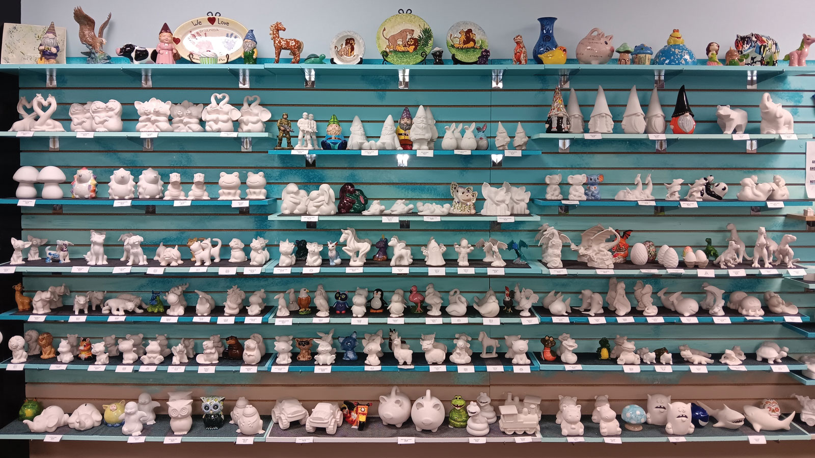 Large Wall of Shelves Filled with Unpainted Pottery Sculptures