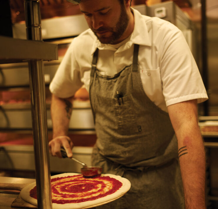 Endwell Taverna chef in kitchen Spreading Sauce