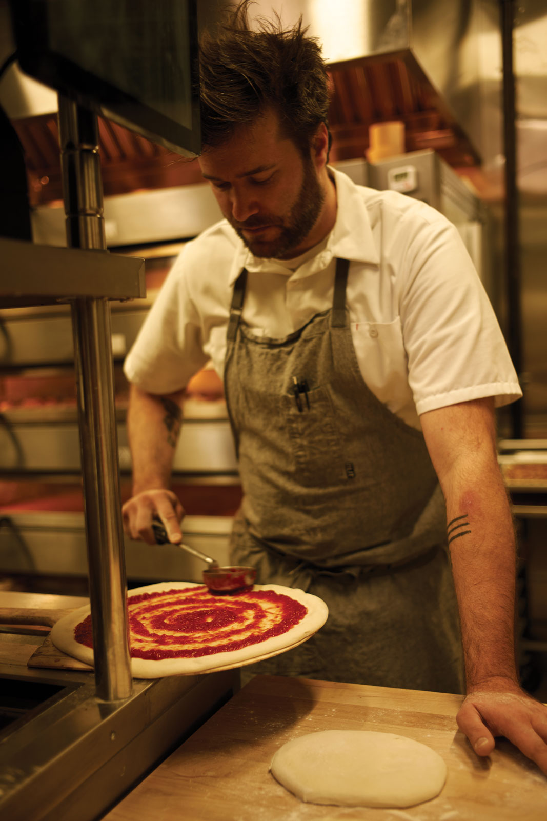 Endwell Taverna chef in kitchen Spreading Sauce