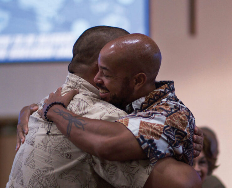 Two men embracing during worship