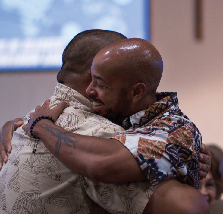 Two men embracing during worship