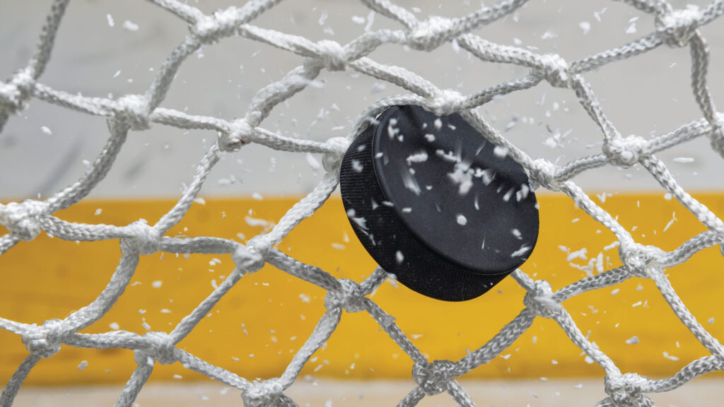 Ice hockey puck hitting the net