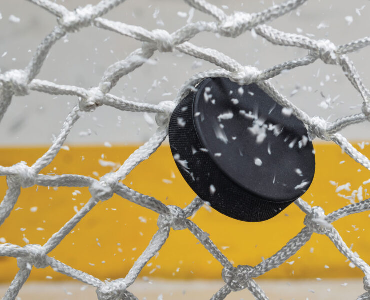 Ice hockey puck hitting the net