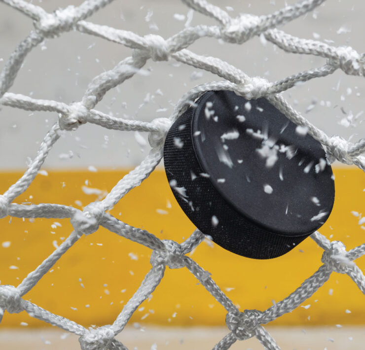 Ice hockey puck hitting the net