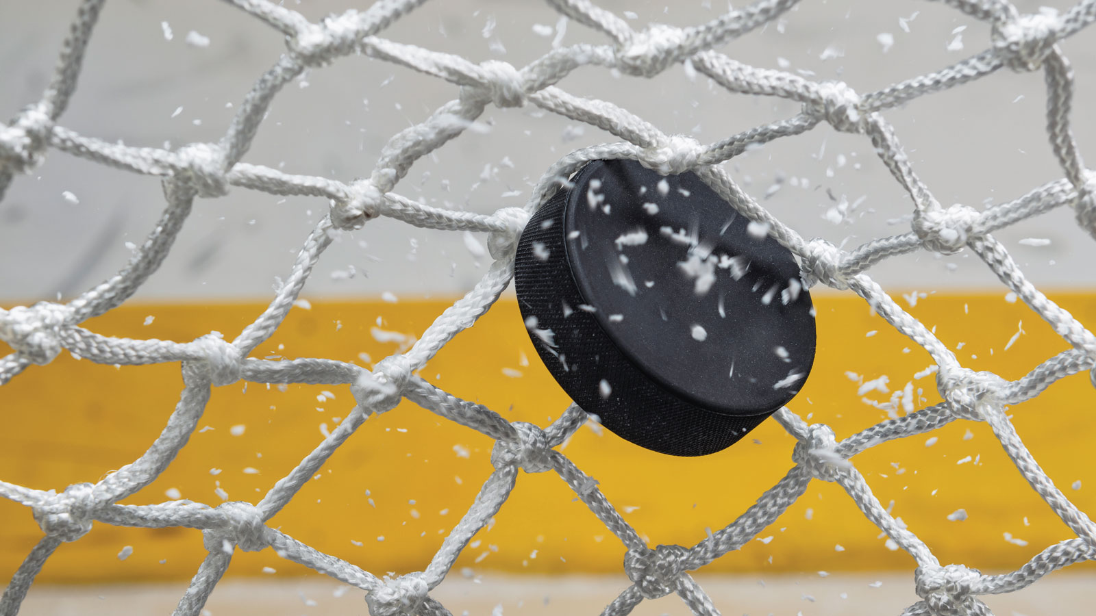 Ice hockey puck hitting the net