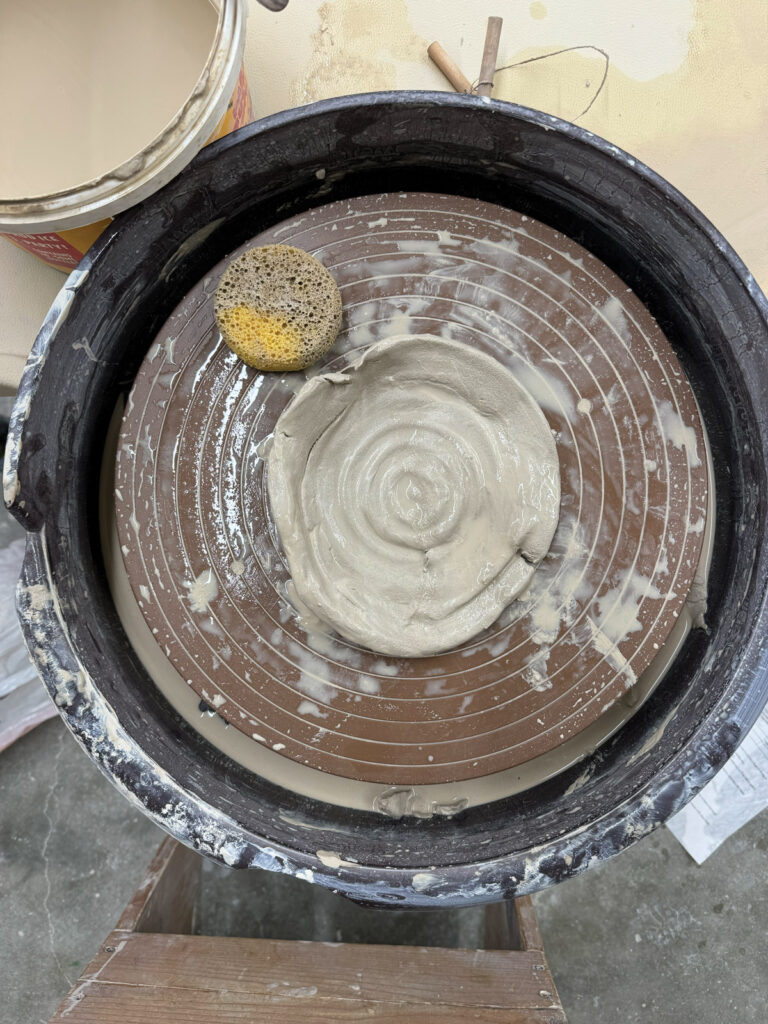 A Pottery Wheel With Unformed Clay Sitting In The Middle