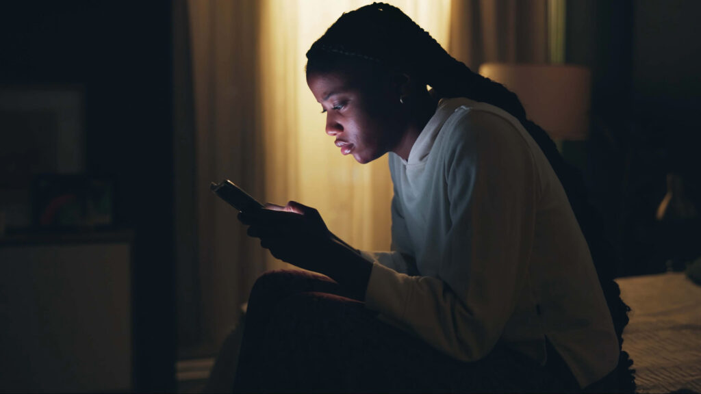 A Stressed Out Teenager Stares At Her Bright Phone Screen