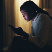 A Stressed Out Teenager Stares At Her Bright Phone Screen