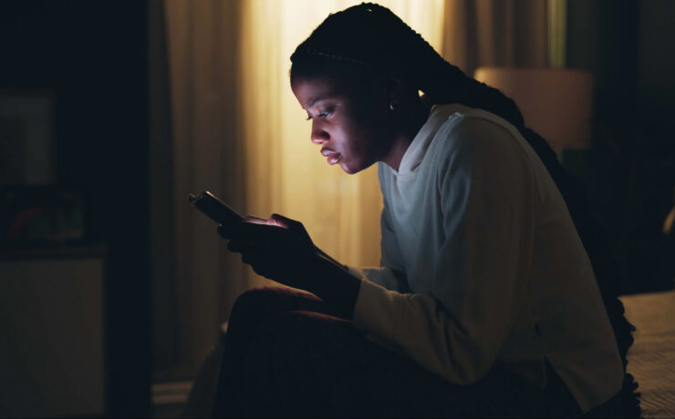 A Stressed Out Teenager Stares At Her Bright Phone Screen