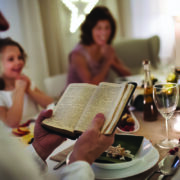 Small Girl With Grandparents Sitting Indoors Celebrating Christmas Together, Bible Reading.