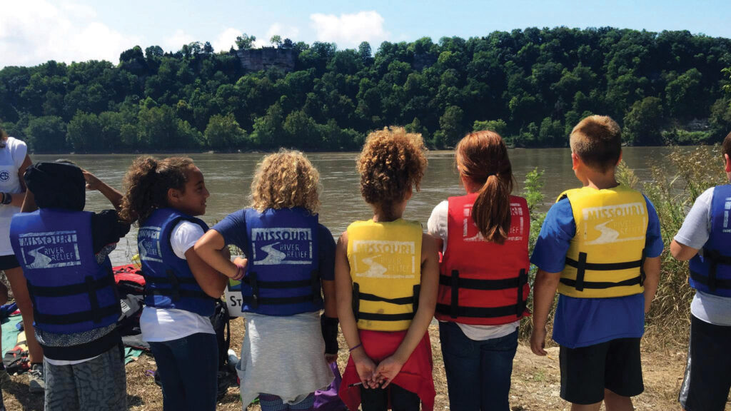 Featured Students standing on the shore of The Missouri River