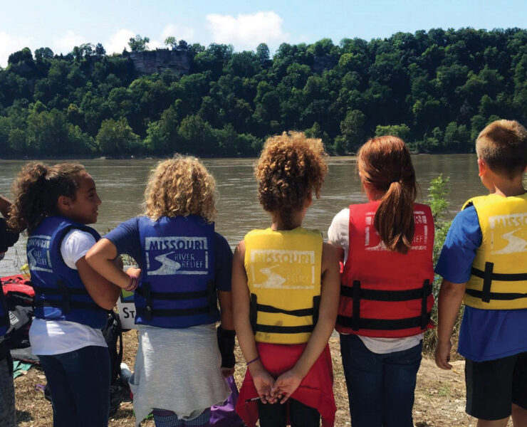 Featured Students standing on the shore of The Missouri River