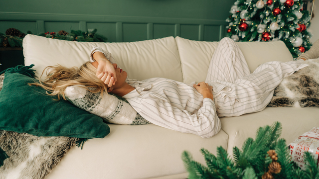 Lady lounging on Holiday couch therapy with christmas tree in the background