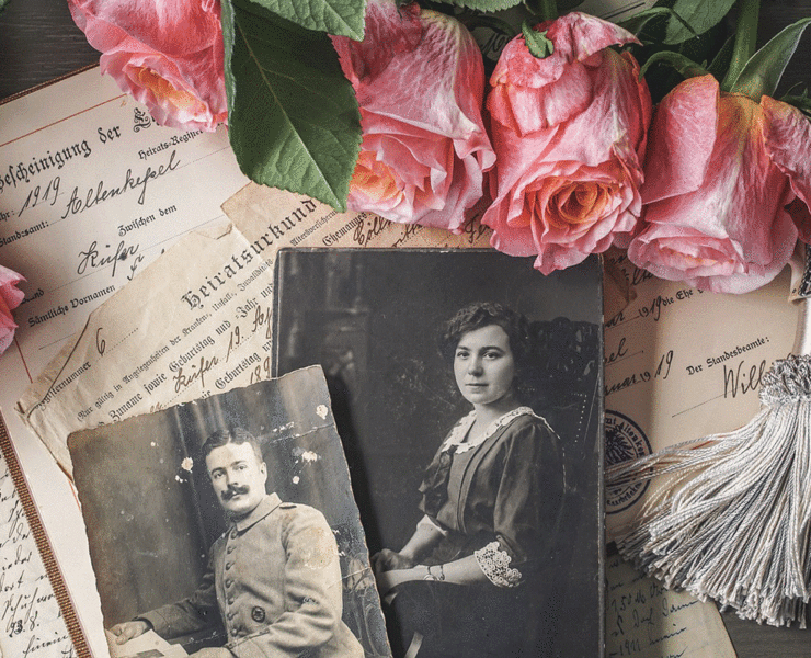 Recollection Agency Stock Feature a collection of vintage portraits and old documents next to a few roses