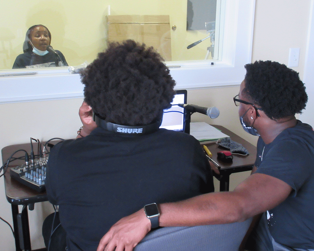  Two members of the Black Archives of Mid-America Youth Council gather an oral history of Beacon Hill leader Jeanene Dunn. The oral history was part of an episode of the Mo' Curious podcast. Photo credit: Trevor Harris 