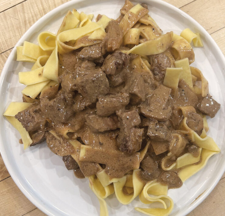 A Plate Of Prepared Beef Stroganoff Over Egg Noodles