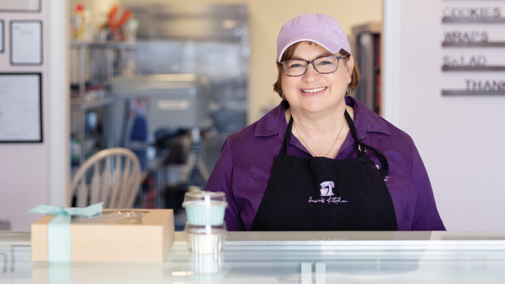 Featured Owner Of Jowins Jean Nicklas Poses Behind Counter