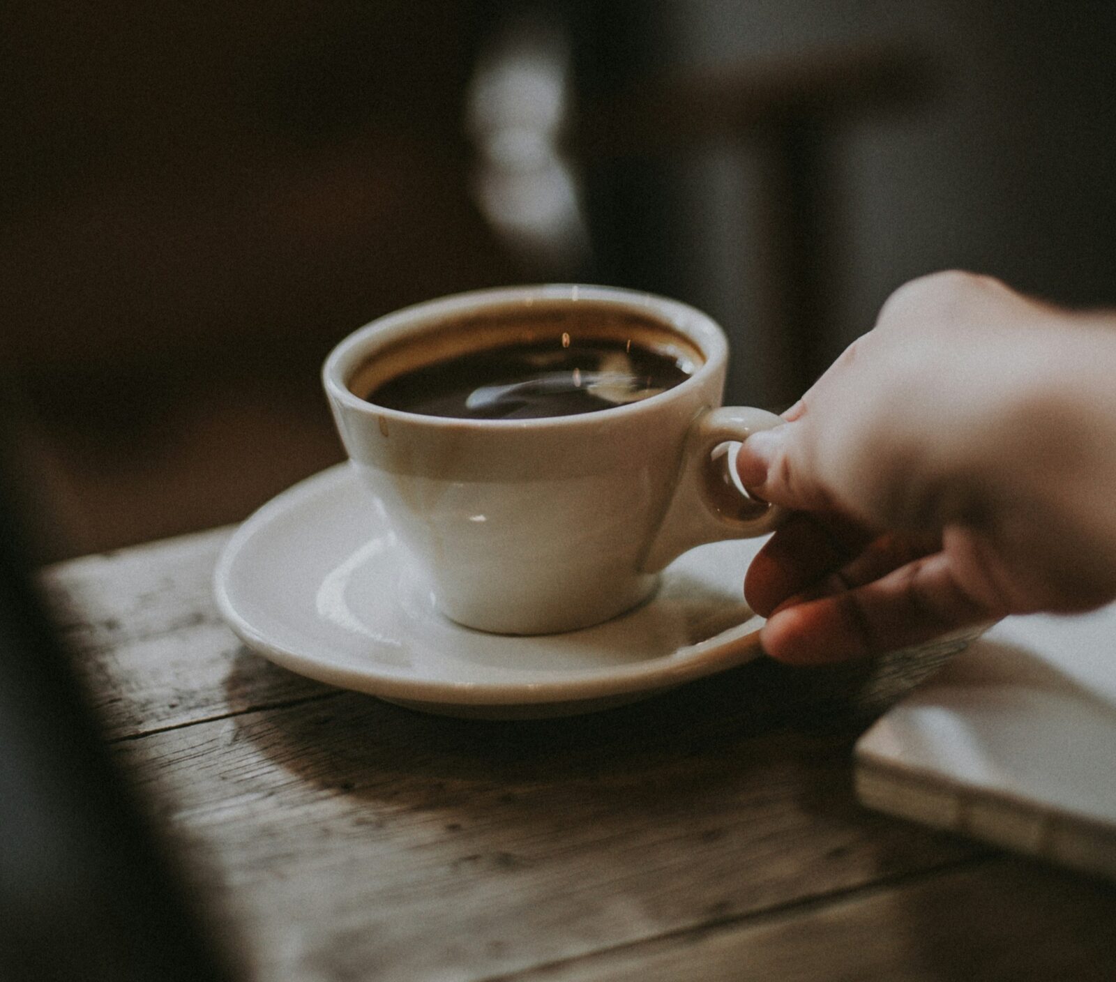 A hand serving coffee