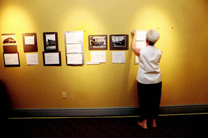 Marge Berchek works on hanging her exhibit on historic vaudeville and moving picture theaters in Columbia. On display at the Missouri Theatre, the exhibit will open in July.