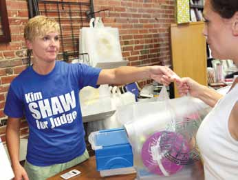 Owner Veronica Kramer hands a customer final purchases during her going-out-of-business sale.
