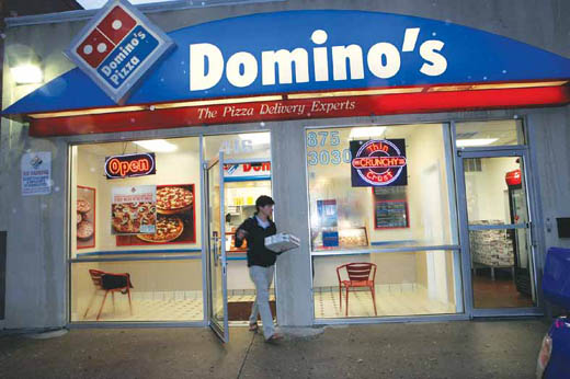 On a rainy night, customers rush in and out of Domino's Pizza on Ninth Street.