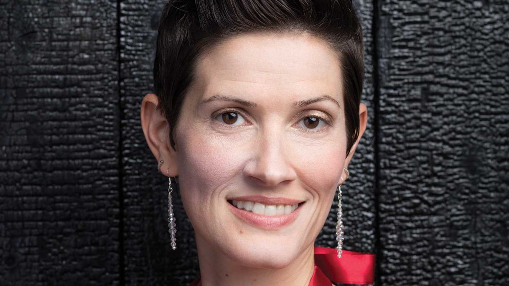 wearing long earrings and a red outfit