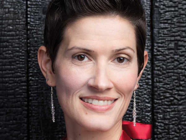 wearing long earrings and a red outfit