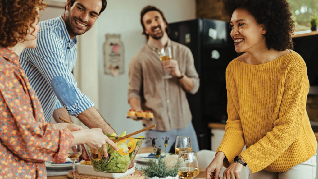 Friend Group Of Adult Couples Cooking Dinner Together