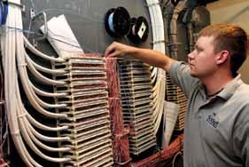Dan Lakaner of Socket troubleshoots a pair of wires while checking the status of a T1 connection in City Hall's data center. City Hall has five T1 lines to meet the city's broadband needs. More than a decade ago, Socket added a fifth T1 line dedicated to dealing with the call volume needs of the billing and protective inspection departments.