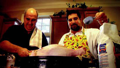 Drane and Burks prepare a turkey in one of the dealership's ads.