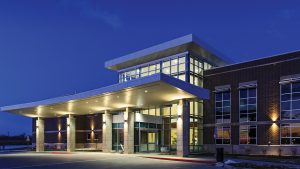 elegantly illuminated at night. Its wide entrance with columns complements the dimly lit surroundings