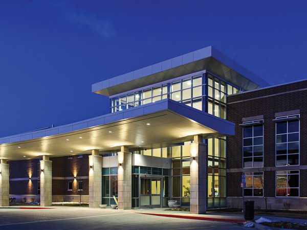 elegantly illuminated at night. Its wide entrance with columns complements the dimly lit surroundings