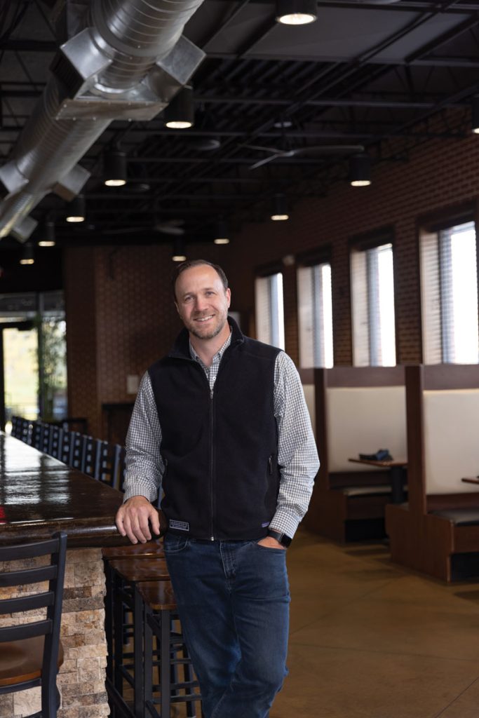 Headshot of a man named Matt Jenne standing in an empty resturant