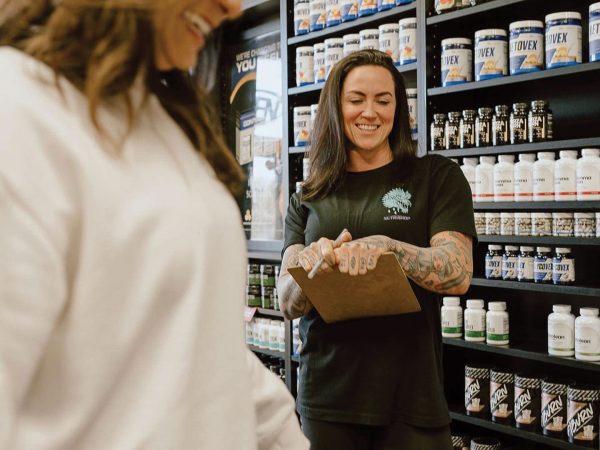 Interior of Nutrishop storefront showcasing stocked shelves and workers ready to help